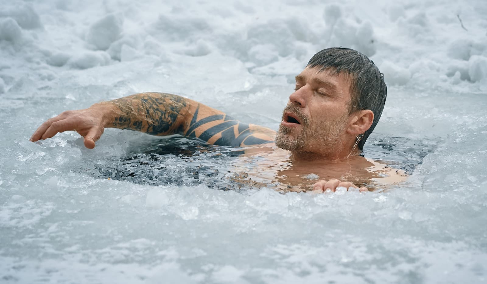 Hombre bañándose en agua helada en invierno
